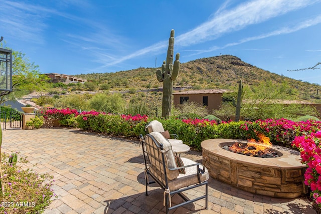 view of patio / terrace with a mountain view and a fire pit