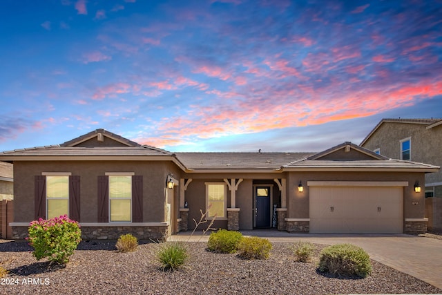 ranch-style home with covered porch, a garage, stone siding, decorative driveway, and stucco siding