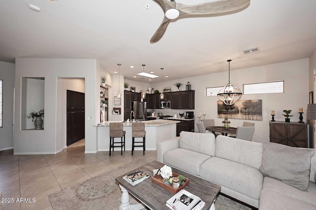 6937 E Purple Shade Cir, Scottsdale, AZ 85266 - living room with a chandelier, light tile patterned flooring, ceiling fan, and baseboards