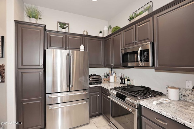 6937 E Purple Shade Cir, Scottsdale, AZ 85266 - kitchen featuring stainless steel appliances, light tile patterned floors, light stone countertops, and dark brown cabinetry
