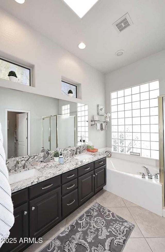 6937 E Purple Shade Cir, Scottsdale, AZ 85266 - bathroom featuring double vanity, a garden tub, tile patterned flooring, a stall shower, and recessed lighting