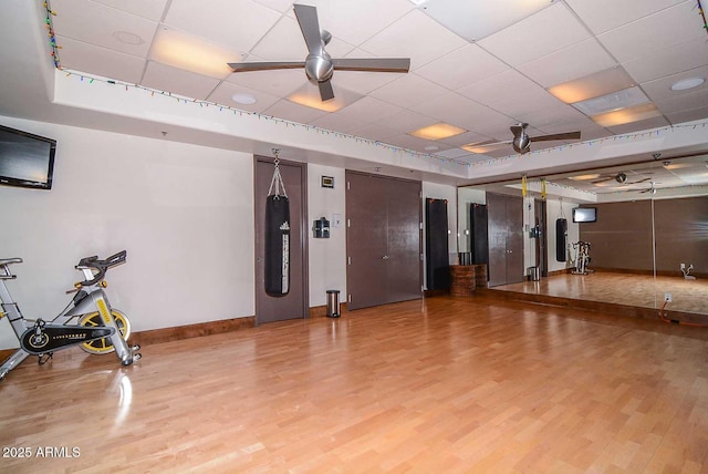 6937 E Purple Shade Cir, Scottsdale, AZ 85266 - workout room with wood finished floors, baseboards, a raised ceiling, ceiling fan, and a drop ceiling