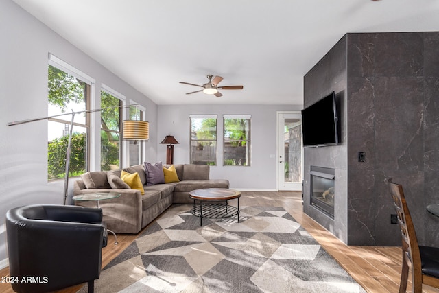 living room featuring a healthy amount of sunlight, ceiling fan, and a large fireplace