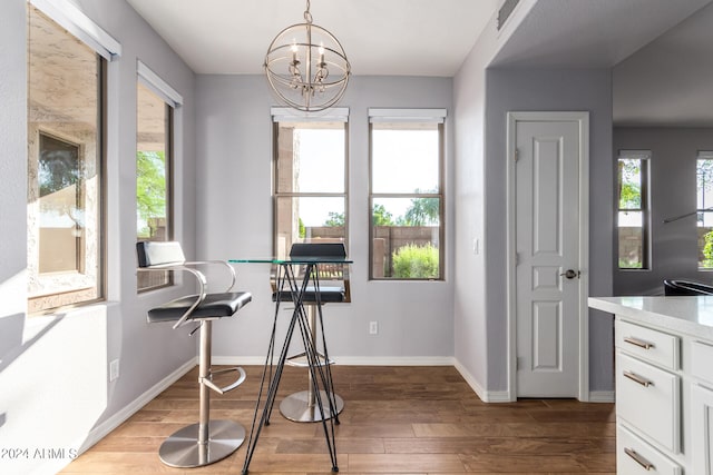 dining room with wood-type flooring and a notable chandelier