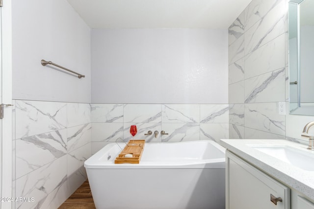 bathroom featuring vanity, tile walls, and a washtub