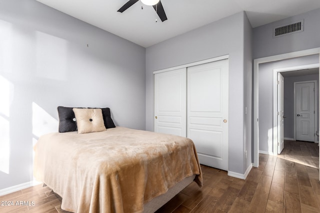 bedroom with dark hardwood / wood-style flooring, ceiling fan, and a closet