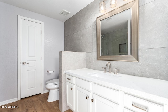 bathroom featuring vanity, toilet, hardwood / wood-style flooring, and walk in shower