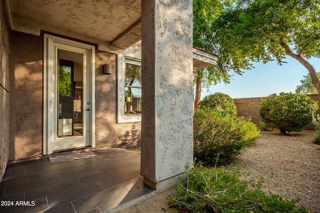 view of exterior entry with a patio