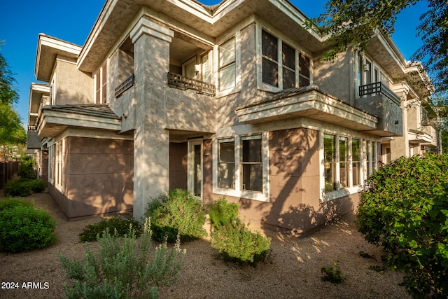 rear view of property with a garage and a balcony