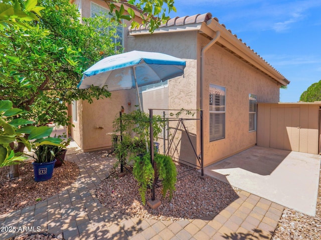981 N Quail Ln, Gilbert, AZ 85233 - view of home's exterior with stucco siding, a patio area, and a tile roof