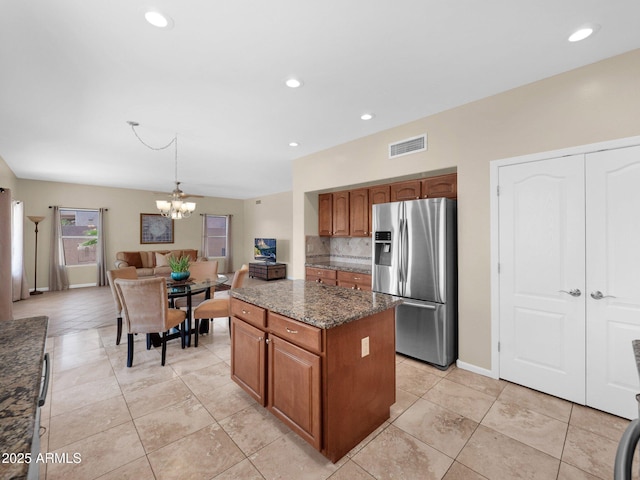 981 N Quail Ln, Gilbert, AZ 85233 - kitchen with stainless steel refrigerator with ice dispenser, a center island, a chandelier, brown cabinets, and recessed lighting