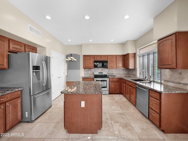 981 N Quail Ln, Gilbert, AZ 85233 - kitchen featuring stainless steel appliances, a kitchen island, dark stone countertops, tasteful backsplash, and recessed lighting