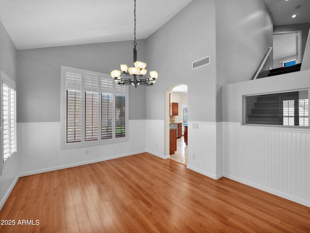 981 N Quail Ln, Gilbert, AZ 85233 - unfurnished room with a wainscoted wall, wood-type flooring, a chandelier, arched walkways, and high vaulted ceiling
