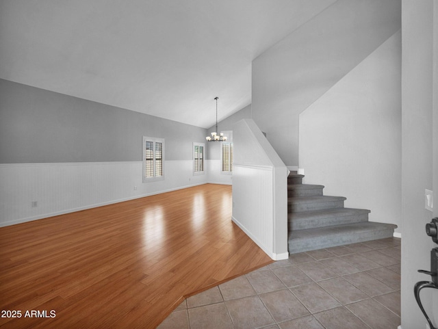 981 N Quail Ln, Gilbert, AZ 85233 - stairway with a chandelier, vaulted ceiling, a wainscoted wall, and wood finished floors