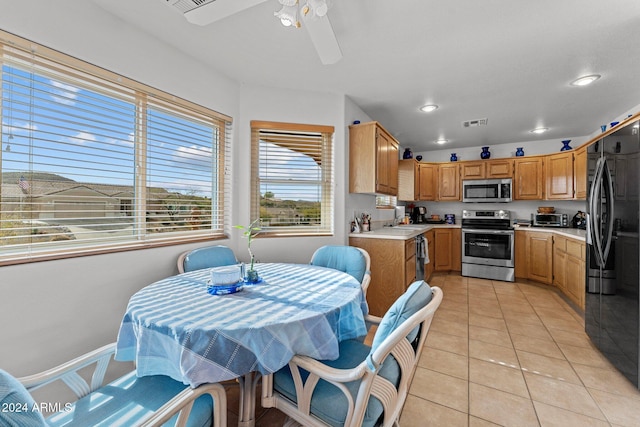 kitchen with ceiling fan, sink, light tile patterned floors, and stainless steel appliances