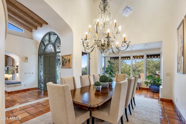 tiled dining area featuring a notable chandelier, beam ceiling, and a towering ceiling