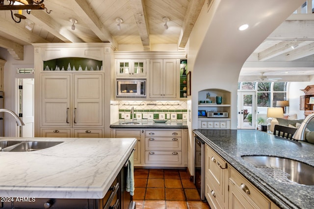 kitchen with beamed ceiling, dark stone countertops, wooden ceiling, and backsplash