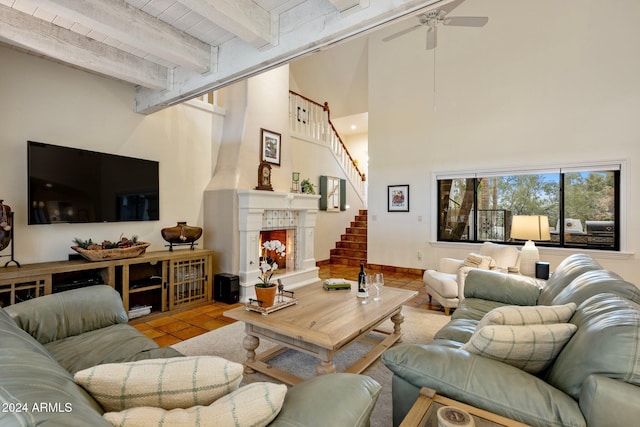 living room featuring wooden ceiling, a high ceiling, ceiling fan, light tile patterned floors, and beamed ceiling