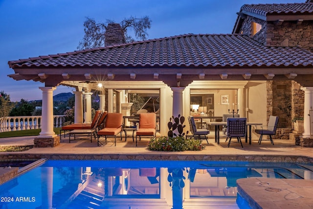 pool at dusk featuring a patio