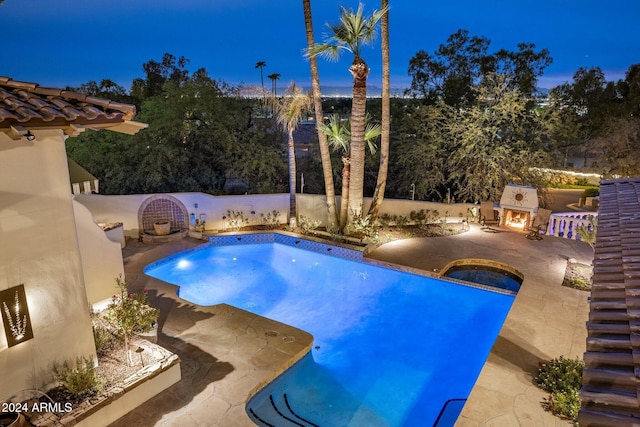 view of swimming pool with an in ground hot tub, exterior fireplace, and a patio area