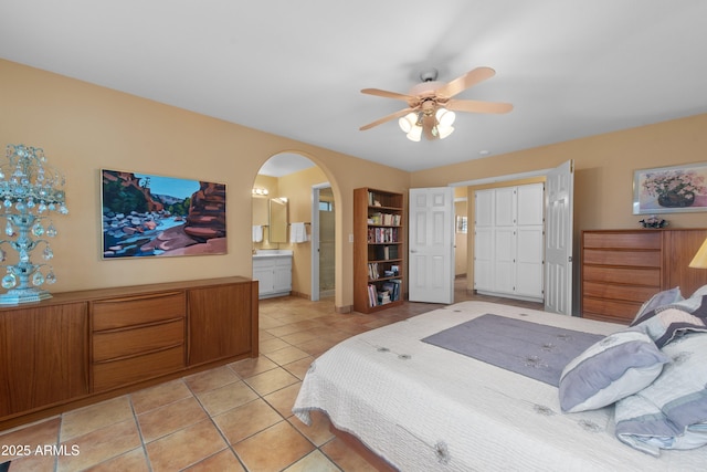 5552 S Feather Bush Ct, Gold Canyon, AZ 85118 - bedroom with arched walkways, light tile patterned floors, ceiling fan, and ensuite bathroom