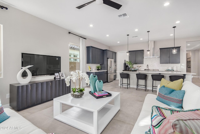 living room with ceiling fan and sink