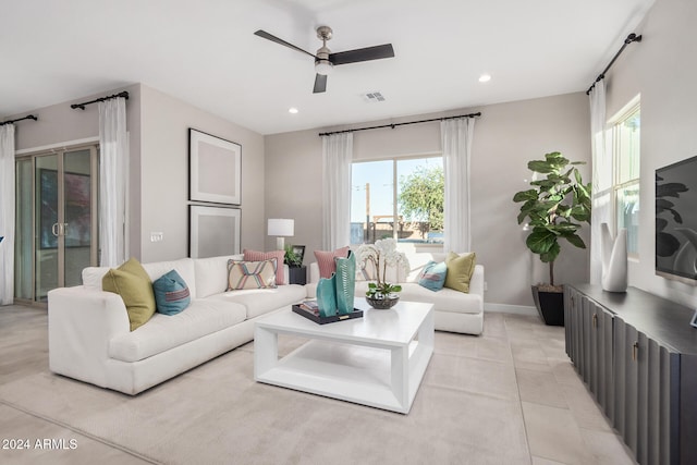 tiled living room with a wealth of natural light and ceiling fan