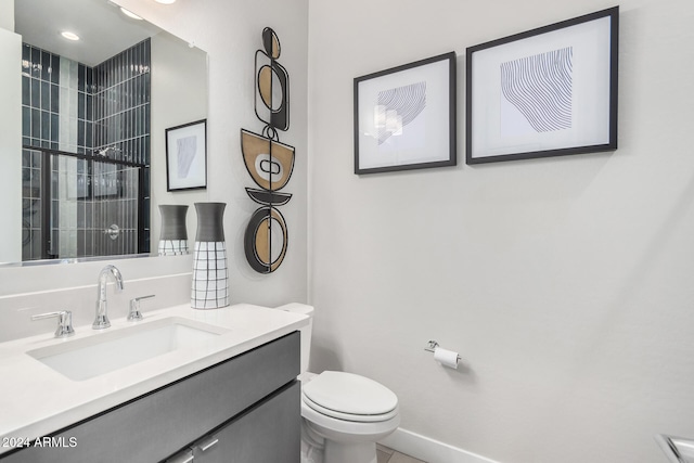 bathroom with tile patterned floors, vanity, toilet, and a tile shower