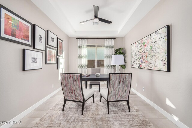 office area with ceiling fan, a raised ceiling, and light tile patterned floors