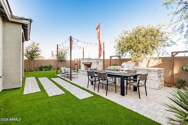 view of yard with an outdoor stone fireplace and a patio area