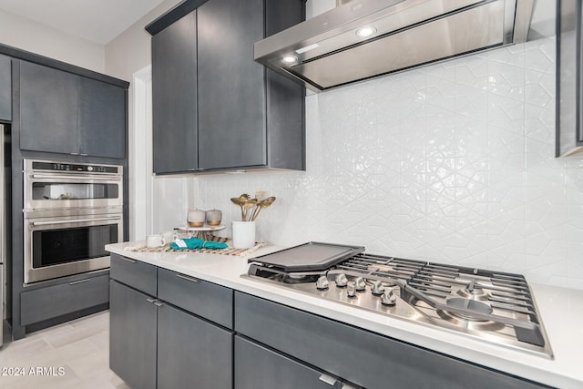 kitchen with decorative backsplash, stainless steel appliances, light tile patterned floors, and ventilation hood