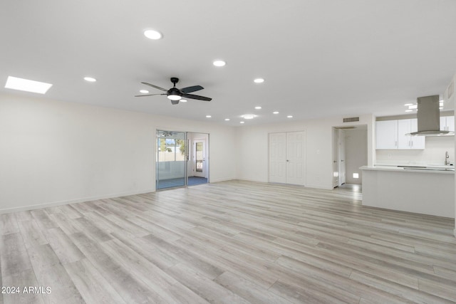 unfurnished living room with light hardwood / wood-style floors and ceiling fan