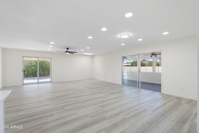 spare room featuring ceiling fan, a wealth of natural light, and light wood-type flooring