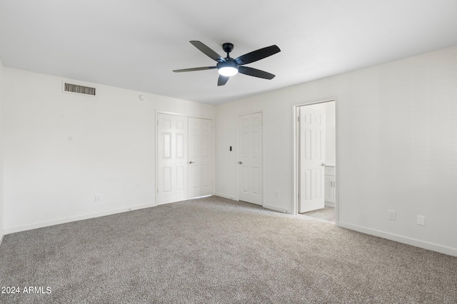 unfurnished bedroom with multiple closets, carpet, and ceiling fan