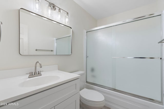 full bathroom featuring vanity, toilet, and shower / bath combination with glass door