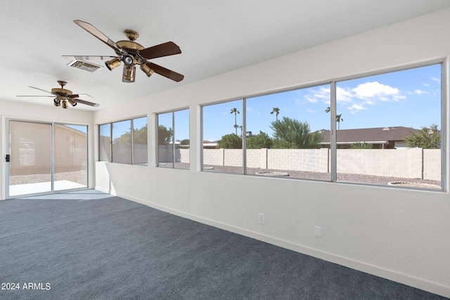 unfurnished sunroom featuring ceiling fan and a wealth of natural light