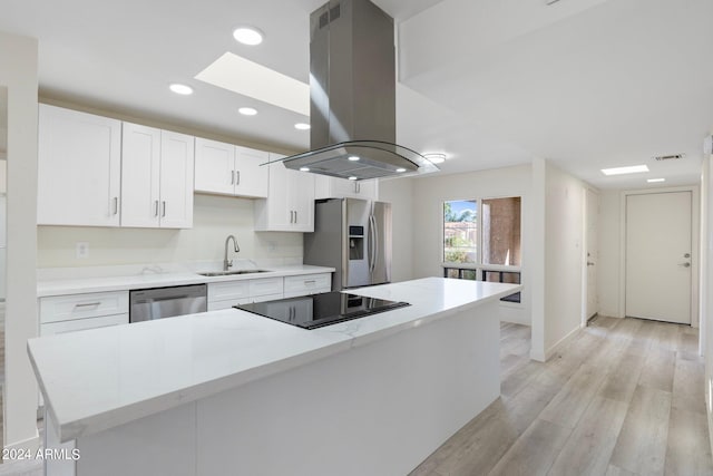 kitchen with sink, island range hood, a center island, stainless steel appliances, and white cabinets