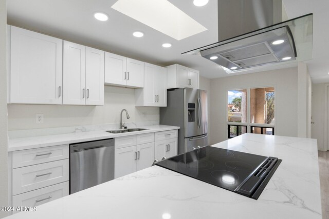 kitchen featuring white cabinets, stainless steel appliances, sink, and light stone counters