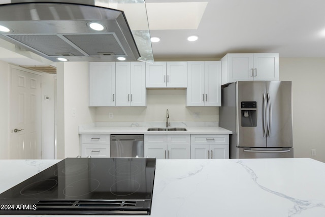 kitchen featuring stainless steel appliances, ventilation hood, light stone countertops, sink, and white cabinets