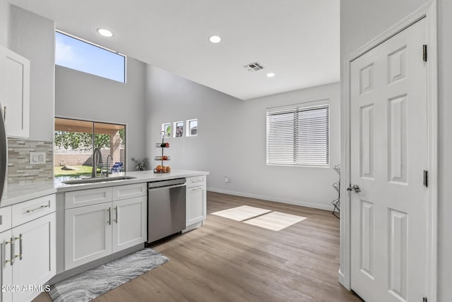 18132 W Cardinal Dr, Goodyear, AZ 85338 - kitchen with stainless steel dishwasher, white cabinets, backsplash, light countertops, and recessed lighting