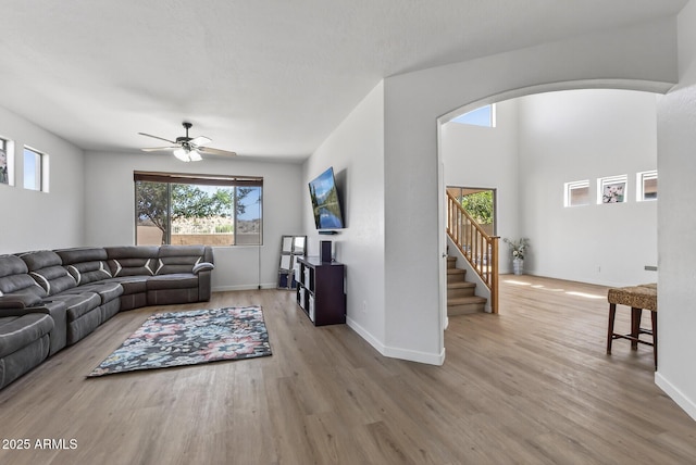 18132 W Cardinal Dr, Goodyear, AZ 85338 - living area featuring wood finished floors, a ceiling fan, stairway, and arched walkways