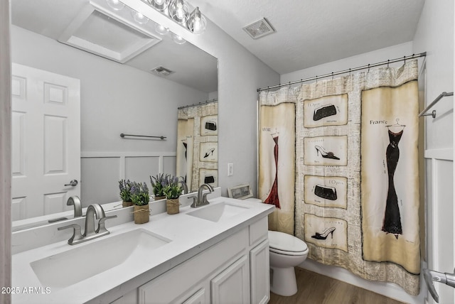 18132 W Cardinal Dr, Goodyear, AZ 85338 - full bathroom featuring double vanity, wood finished floors, and a wainscoted wall
