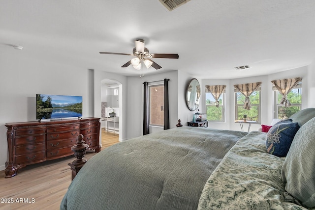 18132 W Cardinal Dr, Goodyear, AZ 85338 - bedroom featuring light wood-style flooring, arched walkways, and ceiling fan
