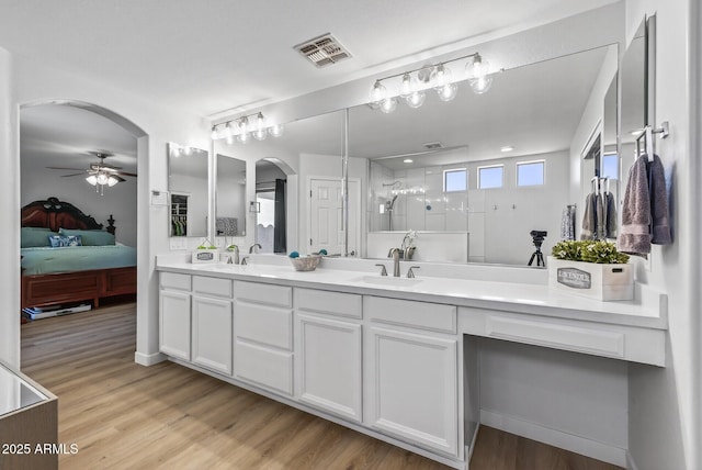 18132 W Cardinal Dr, Goodyear, AZ 85338 - bathroom featuring ensuite bathroom, double vanity, ceiling fan, a walk in shower, and wood finished floors