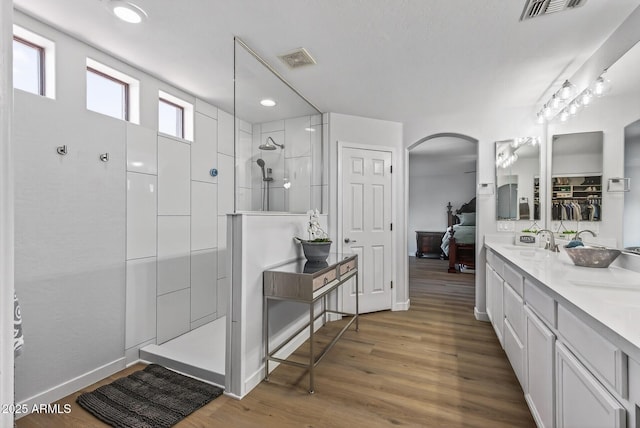 18132 W Cardinal Dr, Goodyear, AZ 85338 - ensuite bathroom featuring walk in shower, double vanity, wood finished floors, and recessed lighting