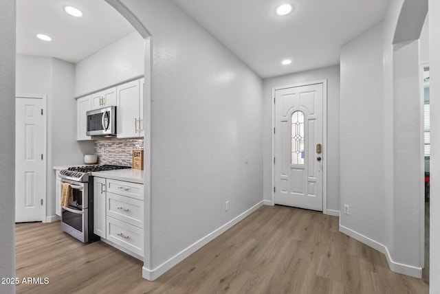 18132 W Cardinal Dr, Goodyear, AZ 85338 - foyer entrance featuring light wood finished floors, arched walkways, and recessed lighting