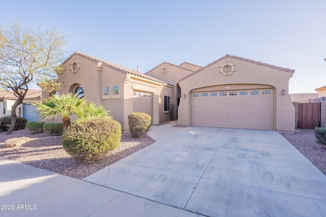 mediterranean / spanish house featuring concrete driveway, a tiled roof, an attached garage, and stucco siding