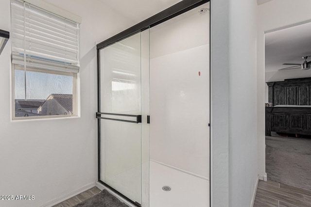 bathroom with a shower stall, wood finished floors, and ceiling fan