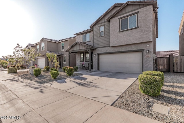 view of front of home with a garage, stucco siding, driveway, and fence