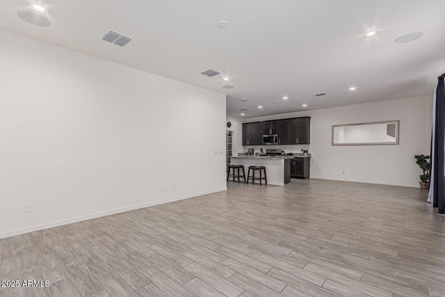 unfurnished living room featuring light wood-style floors, visible vents, and recessed lighting